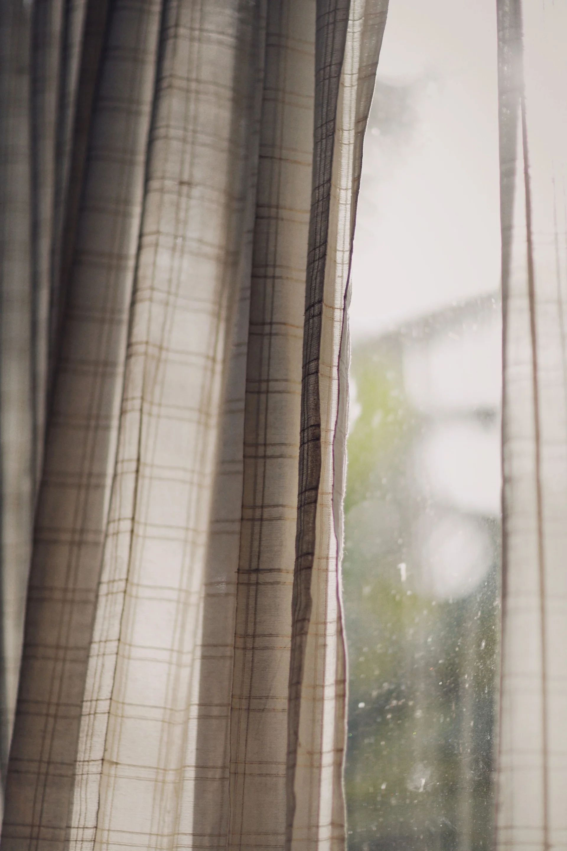 Woven patterned curtain photographed beside a window